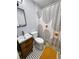 Modern bathroom featuring updated vanity, geometric tile floors, and chic shower curtain, combining style and functionality at 420 61St S Ave, St Petersburg, FL 33705