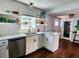 Bright kitchen featuring stainless steel appliances, granite countertops, and stylish shelving, offering both functionality and charm at 420 61St S Ave, St Petersburg, FL 33705