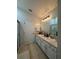 This bathroom offers a double sink vanity, a large mirror, tile floors, and a walk-in shower at 7544 Red Mill Cir, New Port Richey, FL 34653