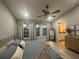 This bright bedroom features a ceiling fan, neutral walls, three windows, and wood-look floors at 7544 Red Mill Cir, New Port Richey, FL 34653