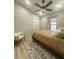 This bright bedroom features a ceiling fan, neutral walls, one window, and wood-look floors at 7544 Red Mill Cir, New Port Richey, FL 34653