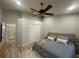 This bright bedroom features a ceiling fan, neutral walls, a closet, and wood-look floors at 7544 Red Mill Cir, New Port Richey, FL 34653