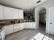 Spacious kitchen featuring white cabinets, neutral counters, and wood-look flooring at 7544 Red Mill Cir, New Port Richey, FL 34653