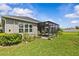 Charming backyard featuring a screened lanai with lush landscaping and a well-maintained lawn at 10516 Tranquil Meadow Loop, Riverview, FL 33569