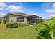 View of a well-maintained lawn, lush landscaping, and screen-enclosed patio at 10516 Tranquil Meadow Loop, Riverview, FL 33569