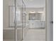 Luxurious bathroom with a glass-enclosed shower, soaking tub, double vanity, and elegant tile work for a spa-like experience at 10516 Tranquil Meadow Loop, Riverview, FL 33569