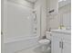 Bathroom featuring a shower-tub combo, tiled walls, vanity and toilet at 10516 Tranquil Meadow Loop, Riverview, FL 33569