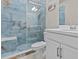 Modern bathroom featuring blue onyx tiled shower with built-in seat and glass door, and white vanity at 10516 Tranquil Meadow Loop, Riverview, FL 33569