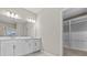 Bathroom showcasing a double vanity, large mirror, and doorway to walk-in closet at 10516 Tranquil Meadow Loop, Riverview, FL 33569