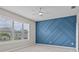 Serene bedroom features a stylish blue accent wall, plantation shutters, and ample natural light, creating a relaxing retreat at 10516 Tranquil Meadow Loop, Riverview, FL 33569