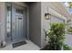Welcoming front entrance with a stylish door, modern lighting, and lush landscaping details at 10516 Tranquil Meadow Loop, Riverview, FL 33569