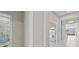 Bright hallway with tile floors leads to a modern bathroom with a blue-tiled shower and stylish storage at 10516 Tranquil Meadow Loop, Riverview, FL 33569
