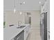 Kitchen island with stainless steel sink, white countertop, stainless steel appliances, and ample cabinet space at 10516 Tranquil Meadow Loop, Riverview, FL 33569