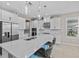 Modern kitchen with a large island, white cabinetry, stainless steel appliances, and pendant lighting at 10516 Tranquil Meadow Loop, Riverview, FL 33569