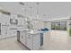 Open-concept kitchen with white cabinets, an island with seating, stainless steel appliances, and natural light at 10516 Tranquil Meadow Loop, Riverview, FL 33569