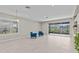 Bright living room featuring large windows, tile floors, and comfortable seating, perfect for relaxation and entertaining at 10516 Tranquil Meadow Loop, Riverview, FL 33569