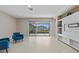 Contemporary living room boasting a built-in entertainment unit, tile floors, and a sliding glass door to the patio at 10516 Tranquil Meadow Loop, Riverview, FL 33569