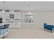 Bright, open-concept living space with tile flooring, modern lighting, and adjacent white kitchen area at 10516 Tranquil Meadow Loop, Riverview, FL 33569