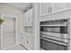 Modern, stainless steel oven and microwave appliances are set in white cabinets at 10516 Tranquil Meadow Loop, Riverview, FL 33569