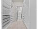 Spacious walk-in closet with custom shelving and drawers, carpet flooring, and washer-dryer at 10516 Tranquil Meadow Loop, Riverview, FL 33569