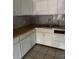 Bright kitchen with white cabinets, grey backsplash, wooden countertop and tile flooring at 27 Tucker Ave, Sarasota, FL 34232
