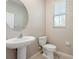 Cozy half bathroom with a pedestal sink and round mirror at 11632 Castine St, New Port Richey, FL 34654