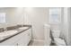 Bright bathroom featuring a double sink vanity with granite countertop and a toilet with a window view at 11632 Castine St, New Port Richey, FL 34654