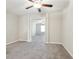 Carpeted bedroom features a ceiling fan and an open doorway to another carpeted room at 11632 Castine St, New Port Richey, FL 34654