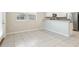 Bright dining area with tile flooring, white cabinets, stainless steel appliances, and a large window at 11632 Castine St, New Port Richey, FL 34654