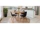 Bright dining area with stylish round table, four chairs, a plant, and access to the kitchen at 11632 Castine St, New Port Richey, FL 34654