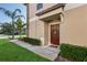Welcoming front entrance features a charming brown door with a wreath, a 'hello' doormat and green landscaping at 11632 Castine St, New Port Richey, FL 34654