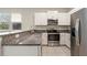 Modern kitchen featuring granite countertops, stainless steel appliances, and white cabinetry at 11632 Castine St, New Port Richey, FL 34654