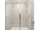 Tiled shower with glass door, shower head, and built in shelves for toiletries at 11632 Castine St, New Port Richey, FL 34654