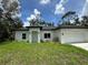 Charming single-story home featuring a well-manicured lawn, white exterior and an attached two-car garage at 353 Warrington Blvd, Port Charlotte, FL 33954