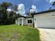 Modern single-story home featuring a well-manicured lawn, white exterior and an attached two-car garage at 353 Warrington Blvd, Port Charlotte, FL 33954