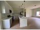 Well-lit kitchen featuring a center island, pendant lighting, stainless steel appliances, and modern cabinetry at 353 Warrington Blvd, Port Charlotte, FL 33954