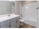This well-lit bathroom features a shower and bath, complemented by a stylish gray vanity and wood flooring at 4861 Antrim Dr, Sarasota, FL 34240