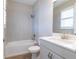 Bright bathroom featuring a shower over tub, white vanity and shuttered windows at 4861 Antrim Dr, Sarasota, FL 34240