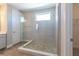 Bright bathroom features a glass shower, a pebble tile floor and a window for natural light at 4861 Antrim Dr, Sarasota, FL 34240