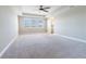 Large bedroom featuring neutral carpet, ceiling fan and windows with bright natural light at 4861 Antrim Dr, Sarasota, FL 34240