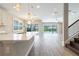 Open kitchen and living area with an island, pendant lighting, and sliding glass doors to the pool at 4861 Antrim Dr, Sarasota, FL 34240