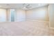 Open loft featuring neutral carpet, a ceiling fan, and abundant natural light from large windows at 4861 Antrim Dr, Sarasota, FL 34240