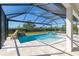 Screened-in pool area with waterfall feature, spa, and a beautiful view of the surrounding landscape at 4861 Antrim Dr, Sarasota, FL 34240