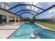 Covered outdoor space overlooks a screened pool and spa with rock waterfall at 4861 Antrim Dr, Sarasota, FL 34240
