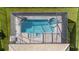 Aerial view of a screened pool and spa with stone accents in a fenced yard at 4861 Antrim Dr, Sarasota, FL 34240