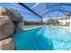 A screened pool with a rock waterfall feature creates a serene backyard escape at 4861 Antrim Dr, Sarasota, FL 34240