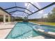 Screened-in pool featuring a spa, waterfall feature, and a tanning ledge for outdoor enjoyment at 4861 Antrim Dr, Sarasota, FL 34240