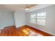 Bright bedroom featuring wood floors, ceiling fan, a large window, and a spacious closet at 2456 S 17Th S Ave, St Petersburg, FL 33712