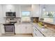 Updated kitchen with stainless appliances, granite counters, grey backsplash and white cabinetry at 2456 S 17Th S Ave, St Petersburg, FL 33712