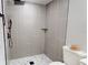 Elegant walk-in shower featuring vertical tile, black matte hardware and convenient toiletry shelf at 2456 S 17Th S Ave, St Petersburg, FL 33712